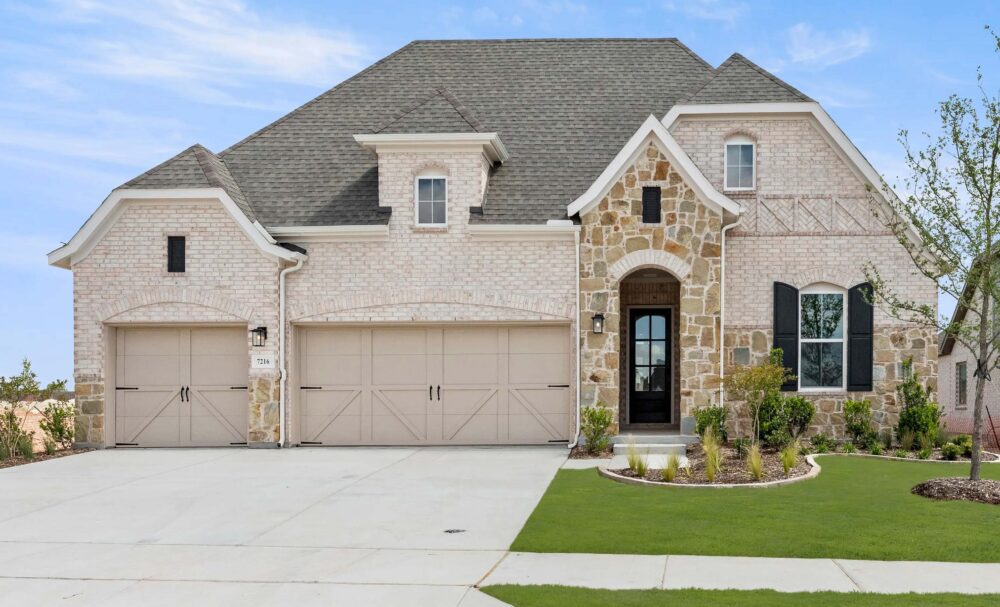 Two-story suburban house in McKinney TX with stone exterior, three-car garage, and landscaped lawn.